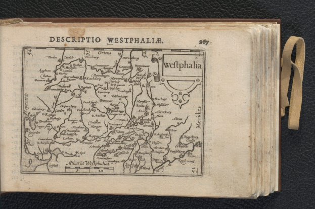 Ein aufgeschlagenes Buch mit einer detaillierten Karte der westfälischen Geographie auf einer schwarzen Oberfläche.