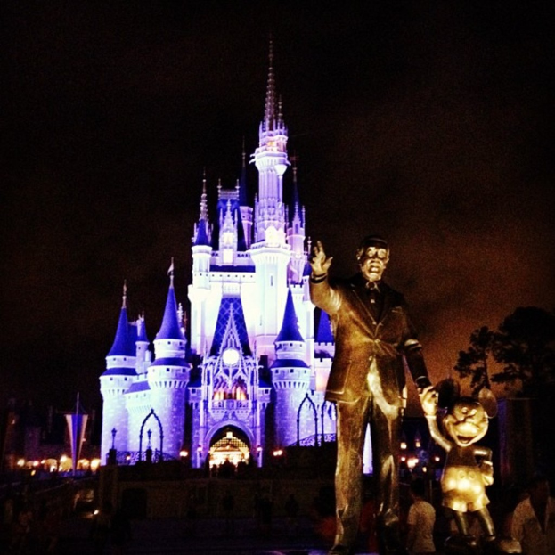 Statuen auf der rechten Seite des Bildes mit Cinderella Castle und Bäumen im Hintergrund.