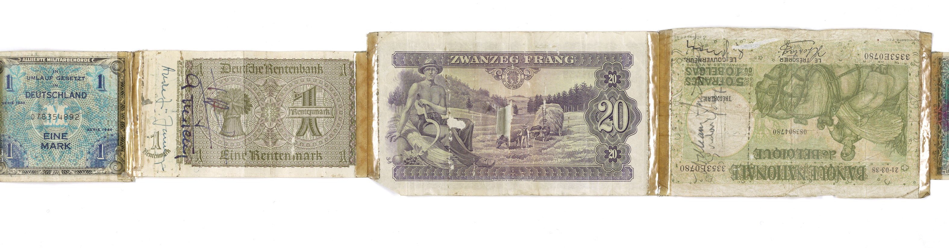 Ein altes Buch mit verschiedenen Scheinen alter deutscher Banknoten darauf gestapelt.