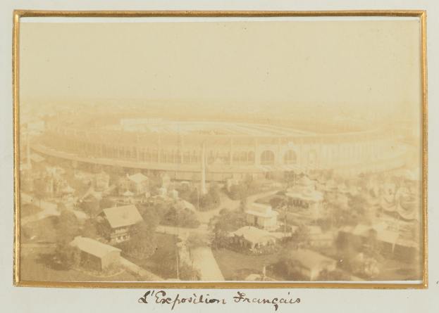 Altes Schwarz-Weiß-Foto eines Stadions in städtischer Umgebung mit umliegenden Gebäuden, Bäumen und Strommasten, mit sichtbarem Text unten.