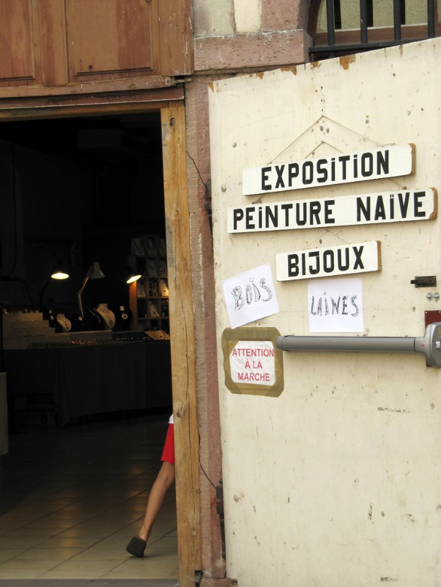 Ein Innenblick in ein Refugium mit einer Person im Hintergrund neben Treppe und Lampen und einer Tür auf der rechten Seite mit Brettern und Text.