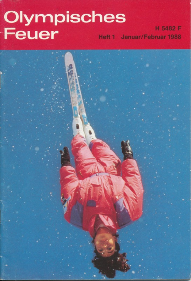Ein Buchumschlag mit einem Skifahrer in der Luft mit entschlossener Miene, der eine Skiausrüstung trägt, mit dem Text "Olympische Spiele Feuer - Heft 1 - Januar/Februar 1988".
