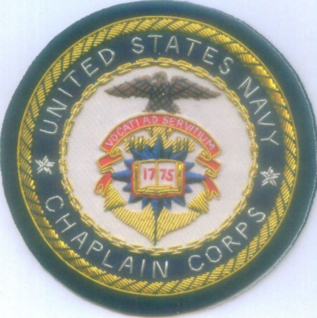 Ein rundes Patch mit blauem Hintergrund und weißer Umrandung, das den weißen Text 'United States Navy Chaplain Corps' in der Mitte zeigt.