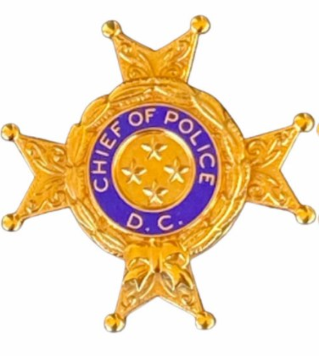 Polizeimarke mit 'Polizei-Chef' Text auf weißem Hintergrund.