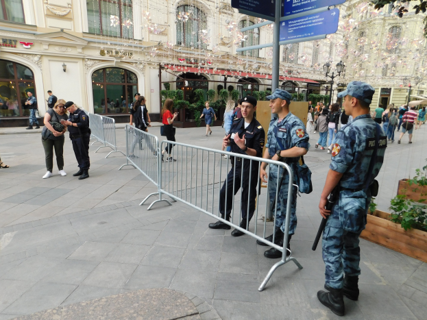 Polizeibeamte in Uniform hinter Barrieren vor einer Menge, einige mit Waffen, mit Gebäuden und Bäumen im Hintergrund während einer Anti-Terror-Operation in Wien, Österreich.