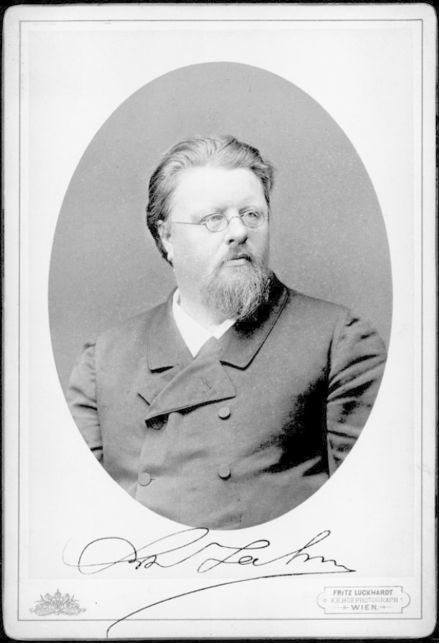 Ein Schwarz-Weiß-Foto eines bärtigen Mannes in einem Mantel mit Brille und der Inschrift "Fritz Luckhardt, Gründer der deutschen Kommunistischen Partei" unten.