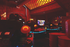 Ein hell erleuchteter Raum voller verschiedener Arcade-Videospielautomaten, Bildschirme und andere Gaming-Ausstattung.