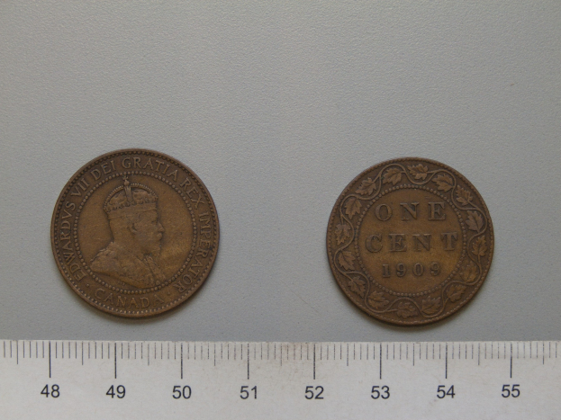 Zwei Ein-Cent-Münzen der USA nebeneinander auf einem Lineal auf einer weißen Oberfläche.