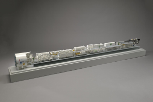 Ein detailliertes Modell des neuen Wasserstoff-Brennstoffzellensystems von Sainsbury's, das einen Kraftstofftank, einen Filter, einen Injektor und eine Energiequelle auf einer weißen Oberfläche zeigt.