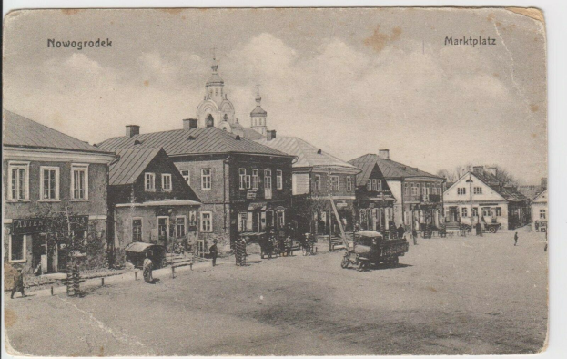 Schwarzer und weißer Fotograf einer Straße in Nowogrodeek, Deutschland, mit Gebäuden, Menschen, Wagen, Pfölen, Bäumen und Himmel sowie dem Text "Marktplatz in Nowogrodeek, Deutschland" oben und unten.