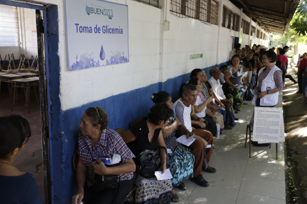 Menschen sitzen auf Bänken vor einem Gebäude und warten in einer Schlange, um an einer Wahllokal in Guadalajara, Mexiko, ihre Stimmen abzugeben.