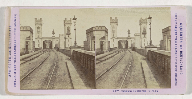 Schwarz-weißes stereoskopisches Bild einer Eisenbahnbrücke in Köln, Deutschland, mit Eisenbahnschienen, Mauern, Pfählen, Statuen, Himmel und Text.