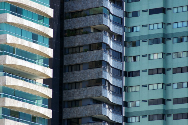 Mehrere Gebäude verschiedener Höhen und Designs sind in einer urbanen Umgebung zu sehen.