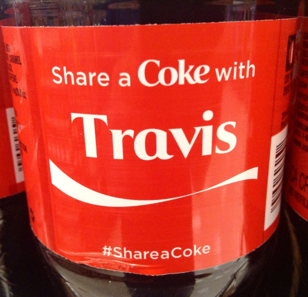 Eine Flasche mit der Aufschrift 'Teile eine Coke mit TRAVIS'.