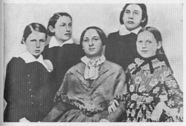 Schwarzes und weißes Foto einer Gruppe von Frauen der Frauenwahlrechtsbewegung, mit einer Frau in der Mitte sitzend.
