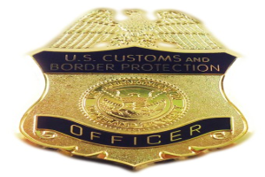 Goldene Abzeichen mit der Aufschrift "U.S. Customs and Border Protection Officer" auf einem weißen Hintergrund.