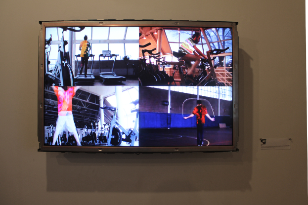 Ein Fernseher an der Wand mit Menschen, die Sport treiben.