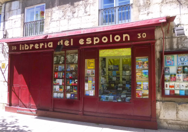 Eine Buchhandlung mit rotem Markisenbuchladen namens "Libreria del Espolon" mit ordentlich angeordneten Büchern, die durch ihre Fenster sichtbar sind.