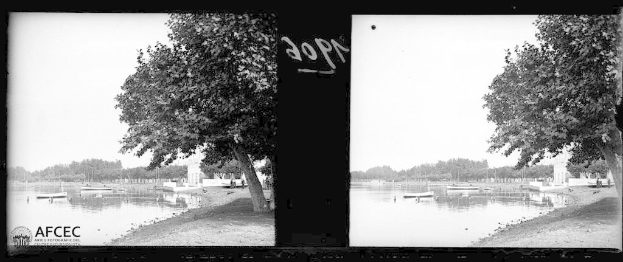 Schwarzes und weißes Foto eines Sees an der Seine in Paris mit Booten, Bäumen und Himmel im Hintergrund.