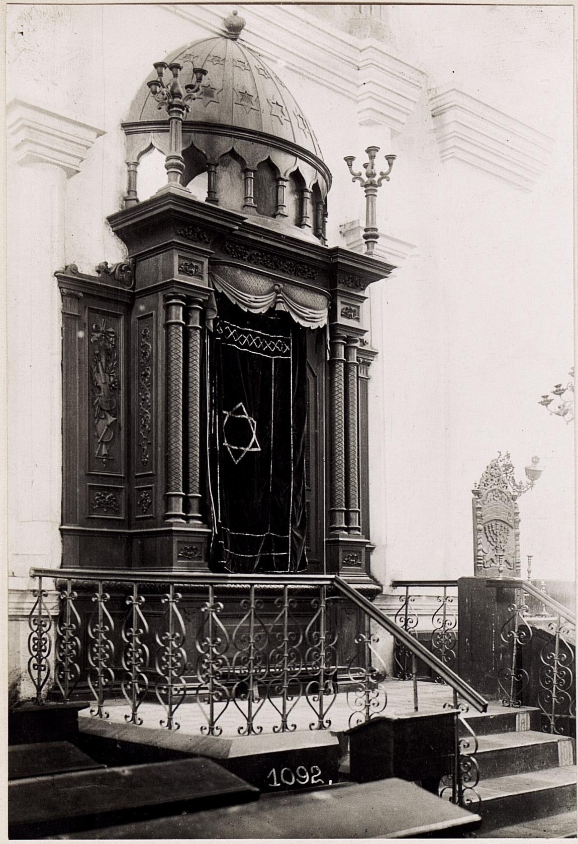 Schwarzes und weißes Foto einer jüdischen Synagoge in New York City mit Treppe, Geländer, Säulen, Tür und Wand.