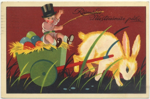 Alte Postkarte mit einem Baby in einem Zylinder, das einen Karren voller bunter Ostereier schiebt und von einem Kaninchen begleitet wird.