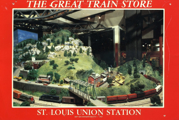 Ein Plakat mit einer Eisenbahn, die eine Brücke mit Trägernkonstruktion überquert, umgeben von Pflanzen, Häusern und Hügeln.