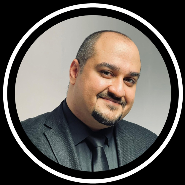 Ein lachender Mann in Anzug und Krawatte vor einem schwarzen Hintergrund, betitelt als Anwalt in New York City.