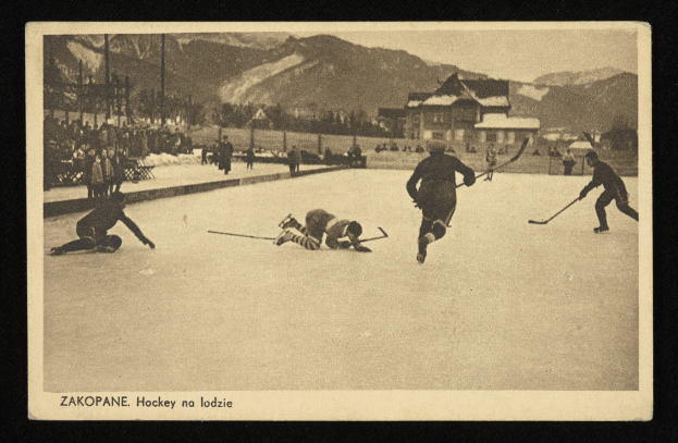Schwarzes und weißes Foto von Menschen, die Hockey auf einem Eisplatz spielen, umgeben von Gebäuden, Bäumen, Pfählen und Bergen im Hintergrund, mit Text unten.