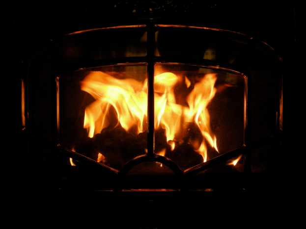 Ein Feuer brennt in einem Kamin mit Holzscheiten.
